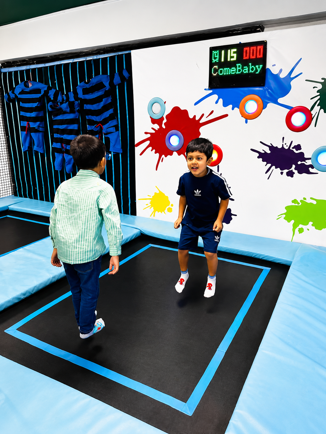 Kids bouncing in the FunSmilez Wonderland trampoline zone with an interactive splatter target wall